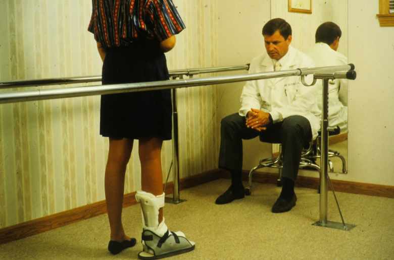 Doctor Examining Patient With Orthotic Brace